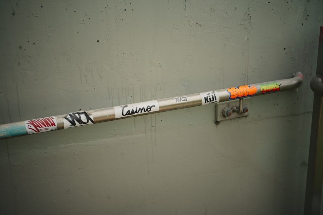 Met stickers bedekte metalen stang aan een wand in een bar